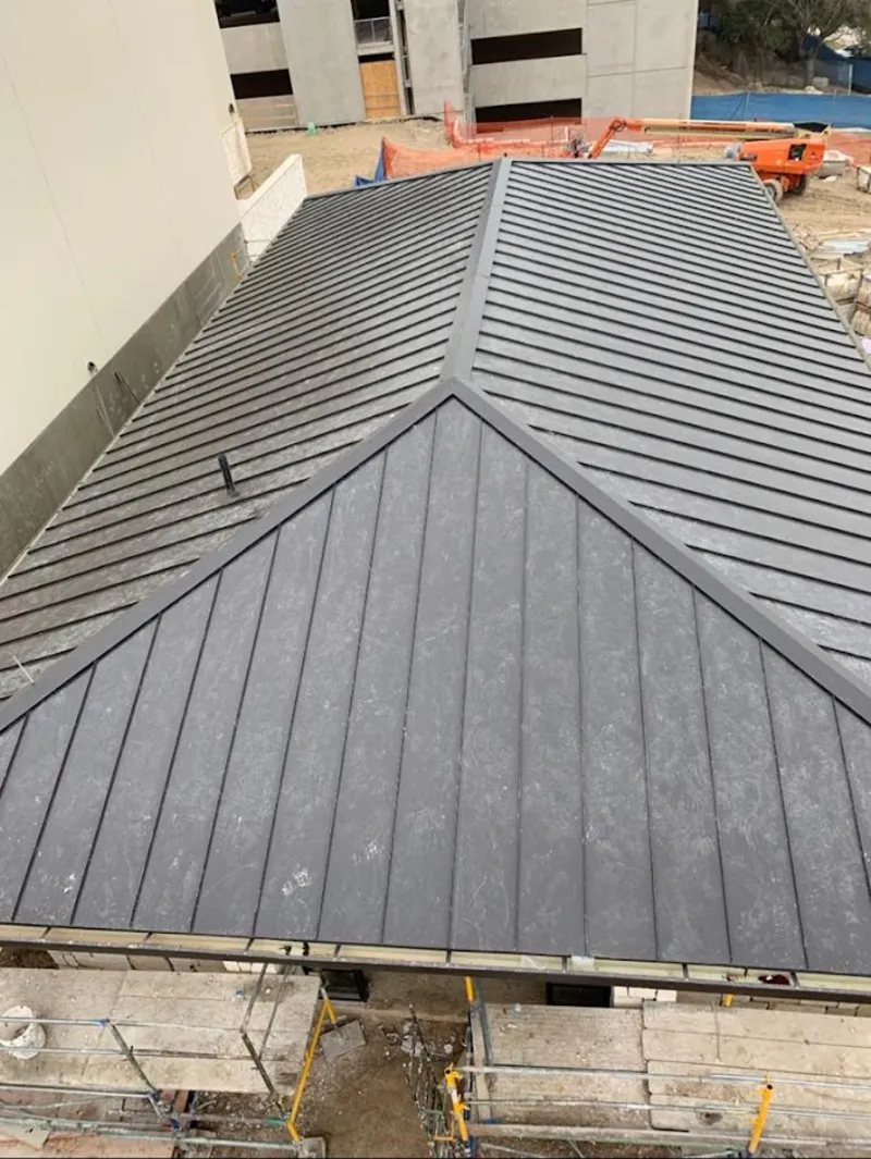 Commercial metal roof construction with crane equipment in Forestville